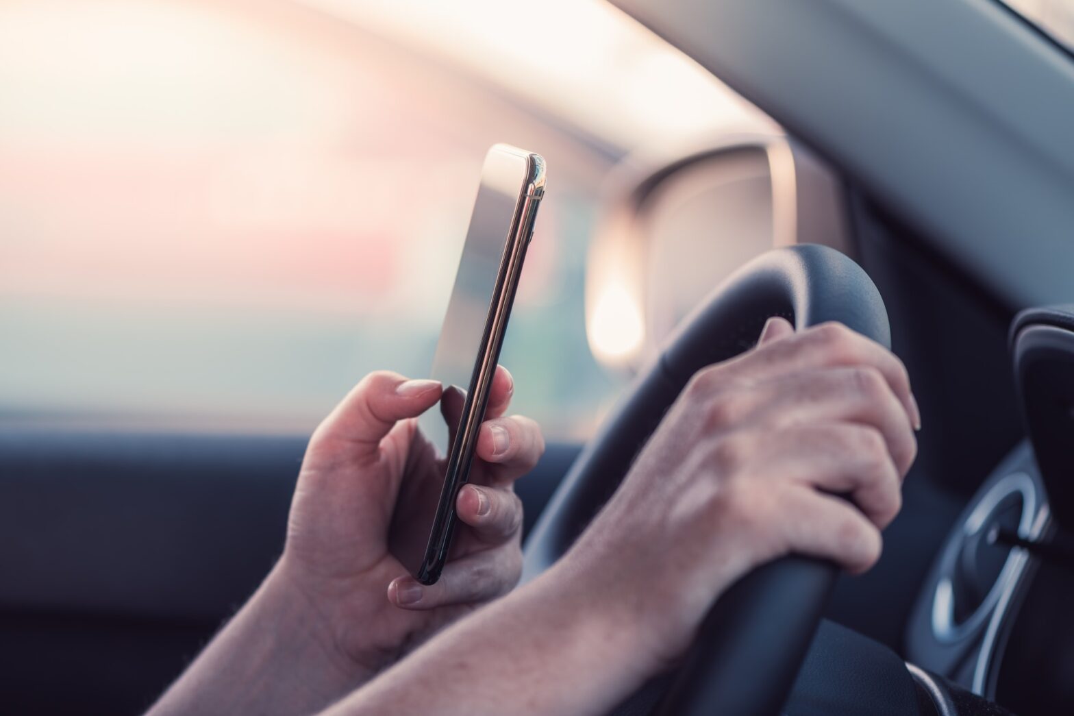 Woman texting on mobile phone in the car