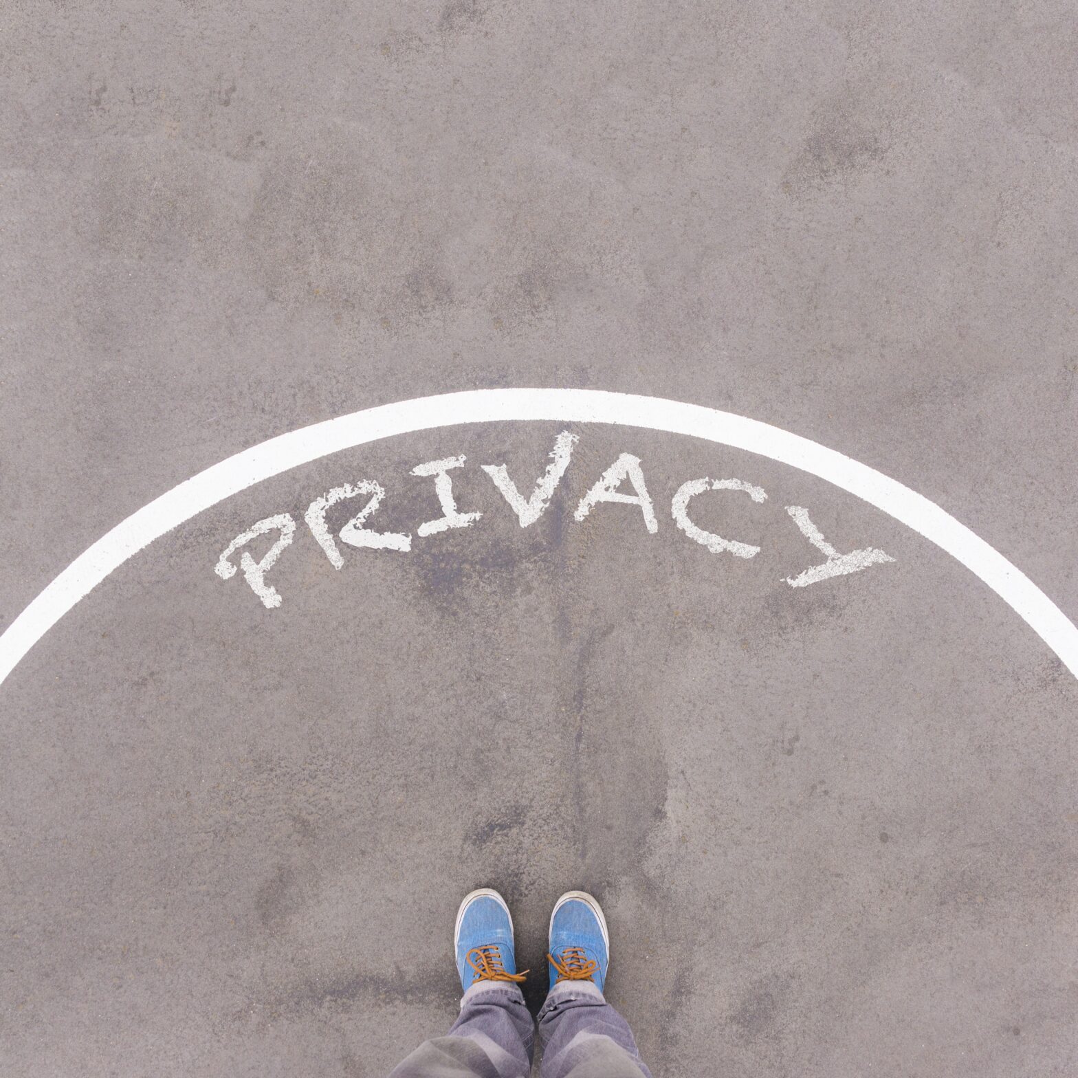 Privacy text on asphalt ground, feet and shoes on floor, personal perspective footsie concept