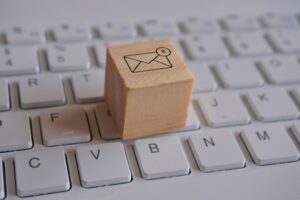 Wooden cube with new email notification icon on top of keyboard.