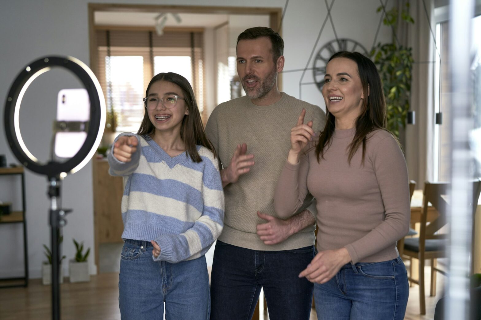 Teenager girl with parents recording dancing for social media