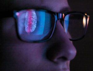 Cyber Security, reflection in spectacles of access information being scanned on computer screen